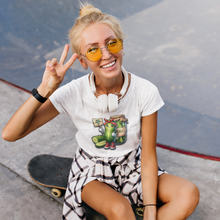 Load image into Gallery viewer, Dill_With_It_Women_s_Slim_Fit_Tee_by_VTown_Designs_worn_by_a_women_sitting_on_a_skateboard_holding_up_two_fingers