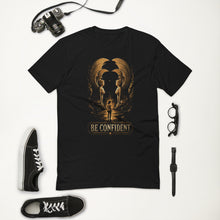 Load image into Gallery viewer, Be Confident Atreyu Sphinx Gate T-Shirt with black shoes, camera, glasses, and watch on a white background