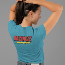Load image into Gallery viewer, Team-Sheldon-Bazina-T-Shirt-worn-byan-attractive-young-woman-showing-back-of-t-shirt-Bazinga