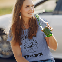 Load image into Gallery viewer, Team Sheldon Bazinga T-Shirt for Fans of The Big Bang Theory woman enjoying a drink