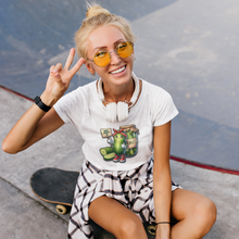 Load image into Gallery viewer, Dill_With_It_Women_s_Slim_Fit_Tee_by_VTown_Designs_worn_by_a_women_sitting_on_a_skateboard_holding_up_two_fingers
