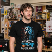 Load image into Gallery viewer, Man wearing Have You Tried Turning It Off and On Again IT T-Shirt and text in a room with shelves and posters.
