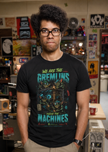 Load image into Gallery viewer, Person wearing a We Are The Gremlins IT T-Shirt | Tech Support Tee, standing in a room with various items on shelves.
