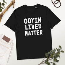 Load image into Gallery viewer, Black t-shirt with 'GOYIM LIVES MATTER' text on a white surface with greenery.
